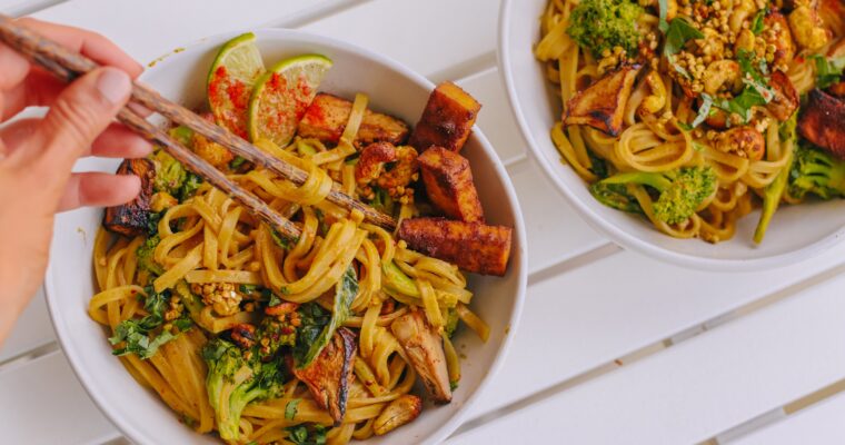 Reisnudeln mit Erdnusssauce, knusprigem Tofu, gebackener Aubergine und Nuss-Granola